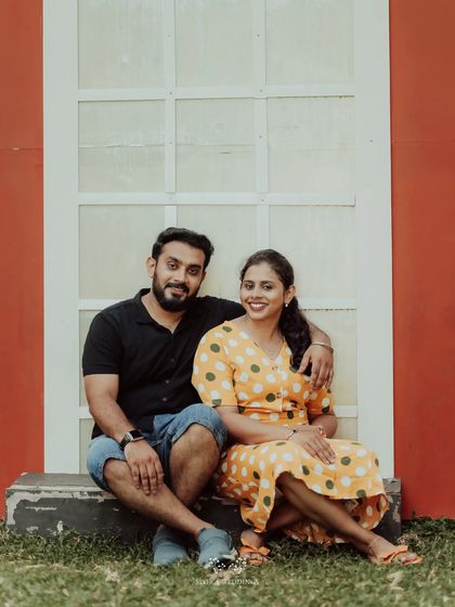 The couple sitting together against a bright wall, a simple and sweet portrait.