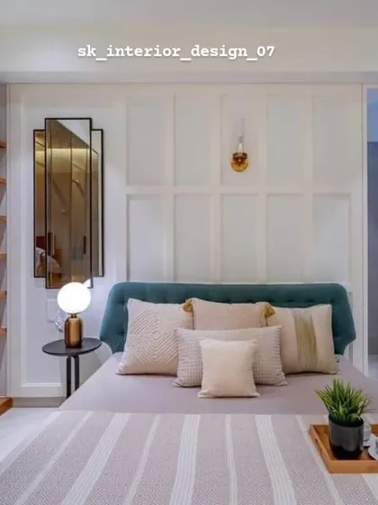 A simple and elegant bedroom with a teal headboard and classic wall paneling. The glass-fronted wardrobe adds a touch of lightness to the room.