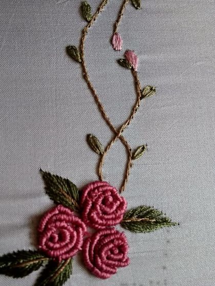 A close-up of intricate rose embroidery, showcasing the skill and patience that goes into creating these beautiful textile details.