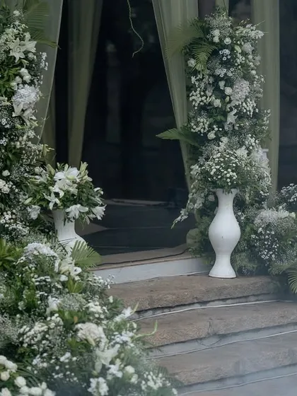 A dreamy entrance decorated with clouds of white flowers and mist, creating a magical welcome for a Sangeet night.