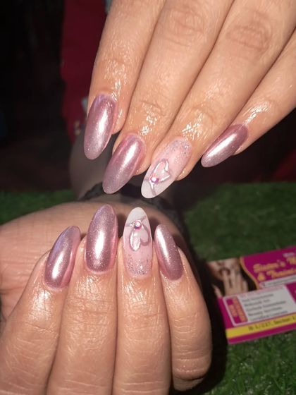 A beautiful rose gold chrome set. The accent nails feature a delicate, sheer base with a hand-painted heart design for a touch of romance.