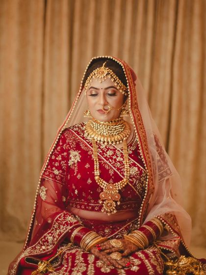A moment of serene contemplation. I asked the bride to close her eyes, focusing the portrait on the incredible detail of her all-gold jewelry and the rich embroidery of her red wedding lehenga.