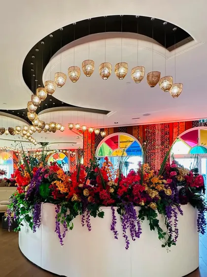 Dotted corners of this palatial venue in Doha with the right amount of color and detailed magic. This vibrant floral arrangement sits beautifully against a backdrop of colorful stained glass.