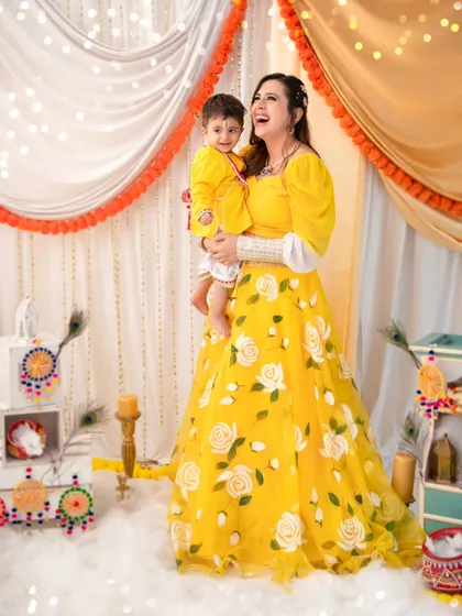 A moment of pure joy between mother and son during their festive photoshoot. Her laughter is infectious as she holds her little Kanha.