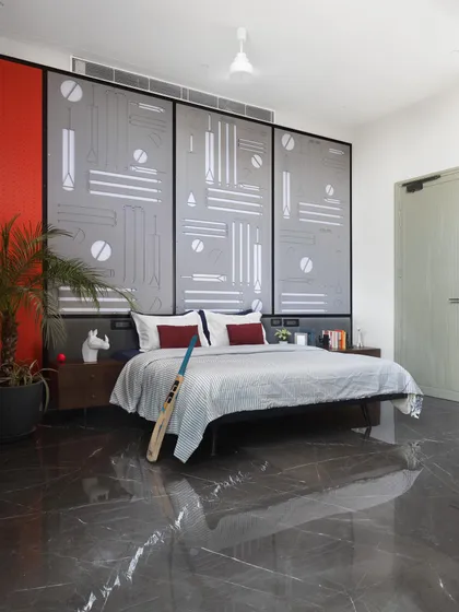 This cricket-themed bedroom was designed for a young sports enthusiast. The custom headboard features abstract graphics of cricket equipment, creating a personalized and stylish space that reflects the child's passion.