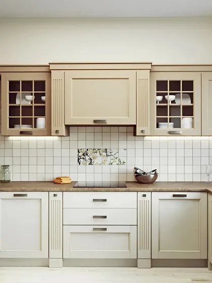 A classic and timeless kitchen design with shaker-style cabinets in a soft beige and white. We included glass-fronted upper cabinets for display and under-cabinet lighting for a warm, inviting glow.