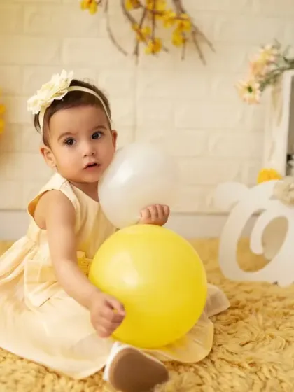 A sweet, curious look from the birthday girl as she plays with balloons. We capture a variety of expressions during our sessions.
