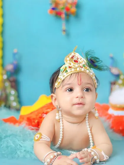 This little one looks so curious during his tummy time pose in the Krishna outfit.
