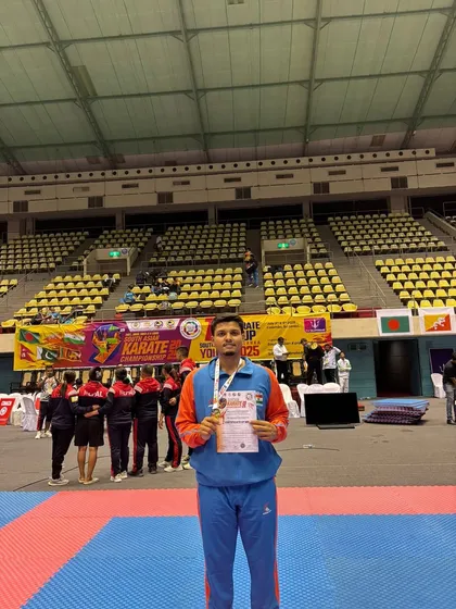 In the arena after his win, Jitendra Kumar holds his gold medal and certificate from the South Asian Karate Championship.