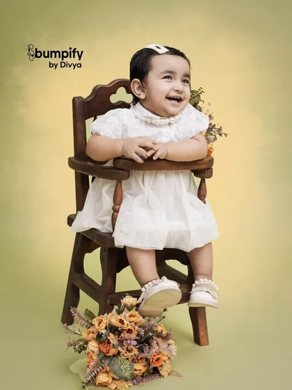 Pure happiness. This little girl's joyful laugh is captured perfectly in this classic studio portrait, using a vintage high chair and a simple, warm background.