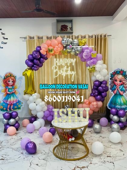 A whimsical fairy theme for Ishu's first birthday. This ring backdrop is decorated with purple, peach, and white balloons, with two fairy cutouts and a custom name table.