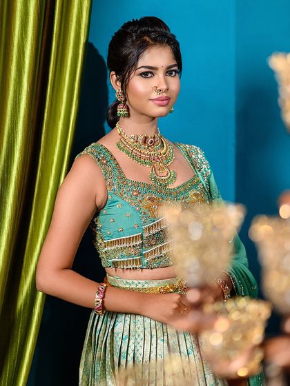 This close-up captures the model's expression and the details of her engagement look. The composition, with the candelabra blurred in the foreground, adds a layer of elegance.