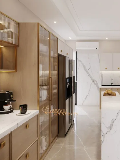 A closer look at the tall pantry units with reeded glass doors and brass frames, providing elegant and accessible storage.