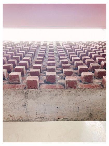 A detail of protruding bricks, creating a textured pattern on a wall. This shows the careful, deliberate use of a simple material.