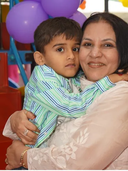 A heartwarming moment between a child and his grandmother at a birthday party, showing that our celebrations are for the whole family to enjoy.