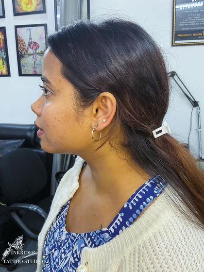 A client with a fresh second lobe piercing, placed just above her existing hoop. I can help with placement for curated ear projects.