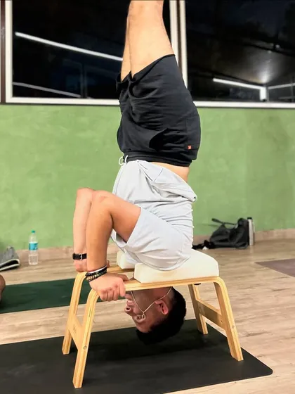 A member uses a headstand bench to safely practice inversions, building confidence and strength without pressure on the neck.