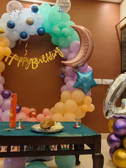 A celestial-themed home decoration for a 4th birthday, featuring a balloon ring with moon and star foils.