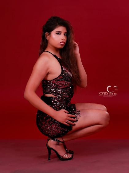Combining a low stance with a direct gaze. This portrait is a blend of power and poise, with the red background amplifying the energy of the shot.
