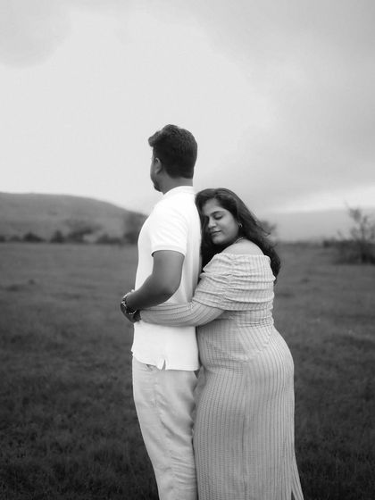 A quiet and tender black and white moment. She rests her head on his back, embracing him from behind as they look out over the landscape, united in their journey.