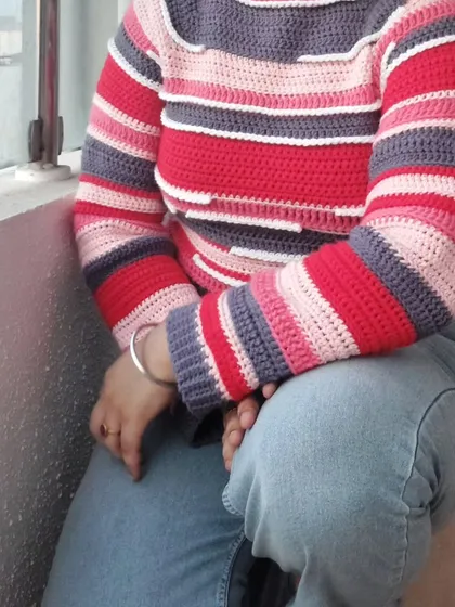 A seated view of the Candy Crush Pullover, highlighting its comfortable drape.