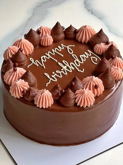 A simple yet beautiful chocolate birthday cake. The rich chocolate ganache is decorated with contrasting pink and chocolate buttercream swirls.