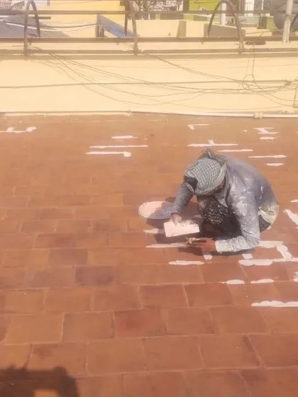 Proper surface preparation is key to effective waterproofing. My process begins with meticulously filling every crack and grout line on the terrace tiles to create a solid, uniform base before applying the final waterproof layers.