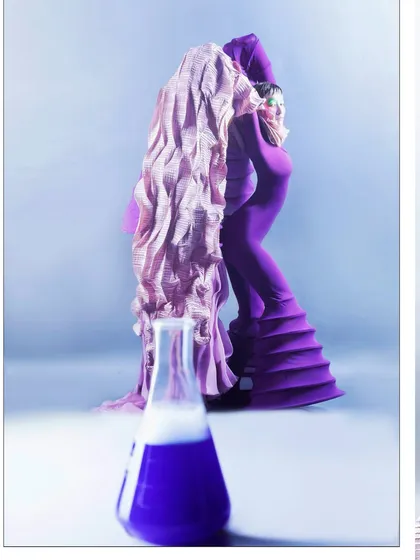 A composite image that juxtaposes the model with a smoking beaker, reinforcing the scientific theme of the 'Chemical Reaction' editorial. The composition links the human form directly to the chemical process.