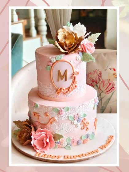 A beautifully photographed vintage-style pink cake with intricate lace piping and a custom monogram.
