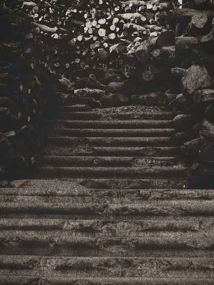 A stark, moody photograph of steps leading up through stacks of wood at Manikarnika Ghat. This image is a powerful meditation on the cycle of life and death, a painful truth that is ever present in Varanasi.