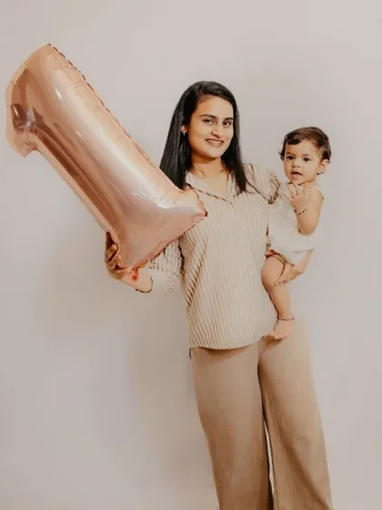 A simple and modern studio-style portrait of a mother and her one-year-old child, celebrating the first birthday milestone together.