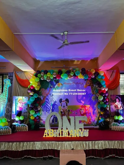 A vibrant jungle-themed stage decoration featuring light-up animal props like a giraffe and elephant, adding a unique touch to the party.