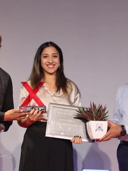 A smiling photo while receiving the TEDx award, a symbol of a significant milestone in my career as an artist and speaker.