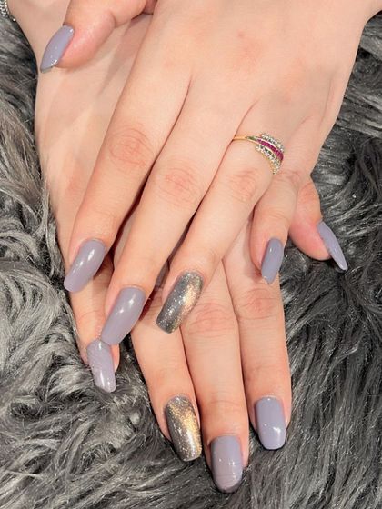 A chic combination of solid grey polish with two accent nails featuring a gold and silver cat eye effect.