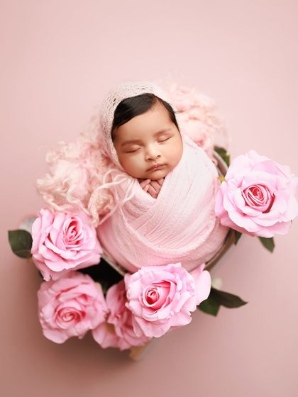 So pretty in pink. This beautiful setup surrounds the sleeping baby with soft pink roses, matching her wrap and creating a truly romantic and feminine portrait.
