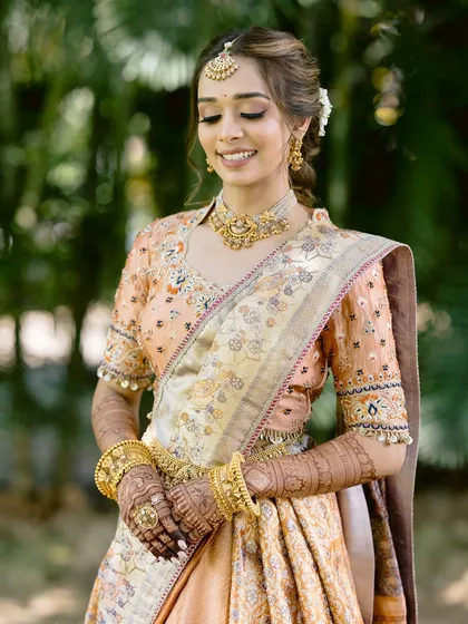 A serene portrait of the bride, showcasing her beautiful smile and the intricate details of her traditional outfit and jewelry.
