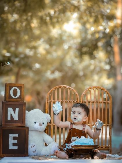 A fun and messy moment from an outdoor cake smash session. The natural background adds a beautiful, rustic feel to this first birthday celebration.