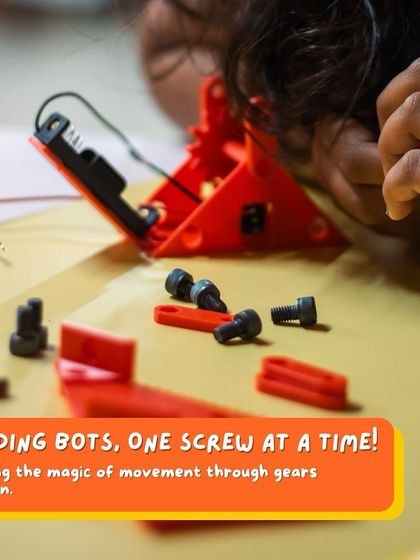 Building bots, one screw at a time. This close-up shows a child learning the magic of movement through the careful assembly of gears.