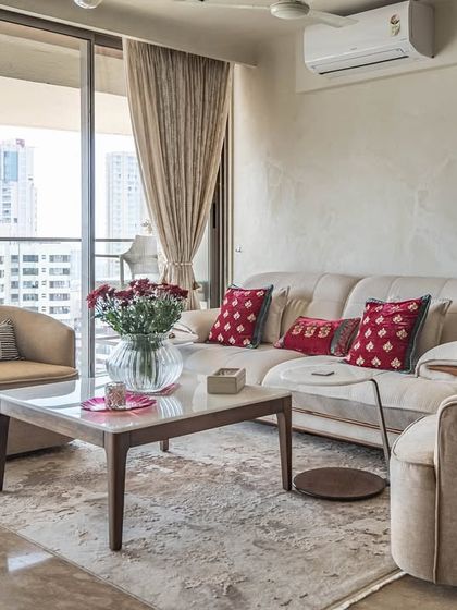 A cozy corner of the 'Eternity' living room, with comfortable, modern armchairs and a view of the city. The neutral tones and soft textiles create a perfect spot for relaxation.