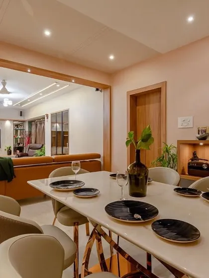 An expansive view from the dining area to the living room, showcasing a large, open-plan space designed for a modern family. The consistent color palette and lighting create a unified and harmonious feel.
