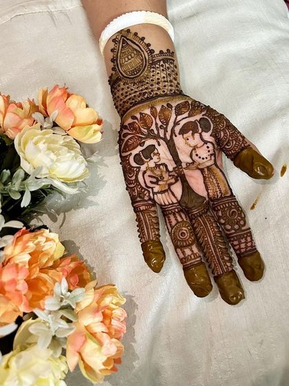 A single hand adorned with a beautiful couple portrait under a tree. This is a wonderful way to symbolize the growth of your relationship in your mehndi design.