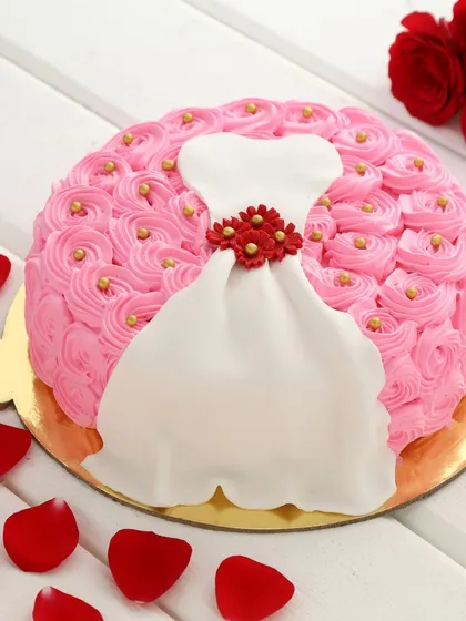 Perfect for a bridal shower, bachelorette party, or a fashion lover's birthday. This cake is decorated with pink rosettes and features a beautifully crafted fondant dress design.