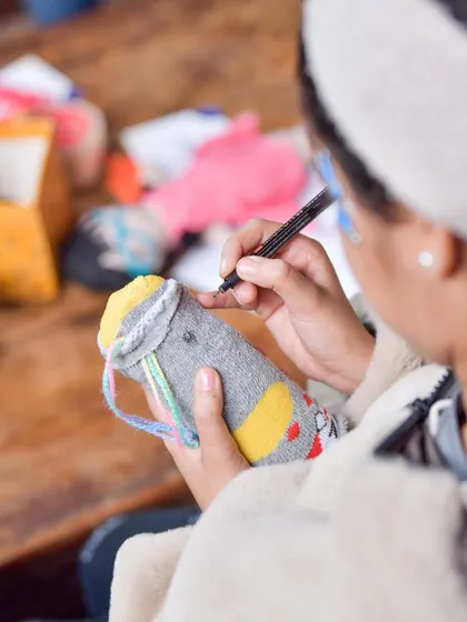 A close-up of our doll-making activity, where a child is carefully crafting a sock puppet. These hands-on sessions are a core part of my Sunday brunch experience, designed to engage and inspire young minds.