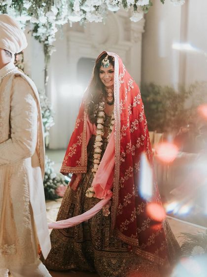 A dreamy shot of the bride during her pheras. The soft focus and lighting create a magical feel, with her makeup looking ethereal.