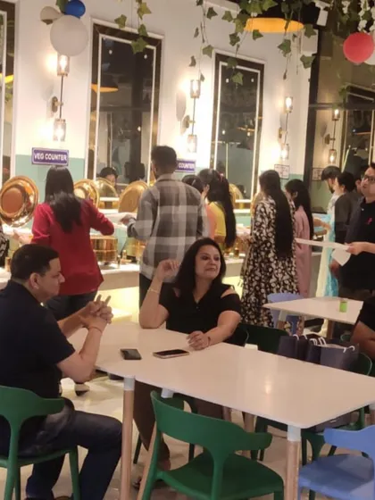 Guests enjoying their meal in the comfortable seating area. I have arranged the tables to allow for both intimate conversations and larger group gatherings.