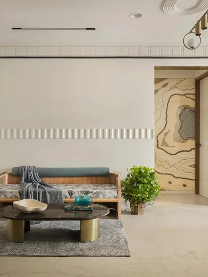 A view of the living room showing the custom daybed and the stunning resin art panel on the far wall.
