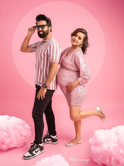A fun and playful couple's shot with a vibrant pink theme. Their coordinated poses and joyful expressions perfectly capture the excitement of expecting.