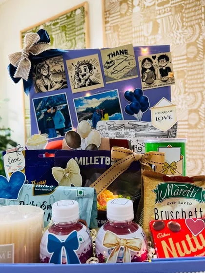 The complete five-year anniversary hamper, filled with their favorite snacks, a scented candle, and personalized details.