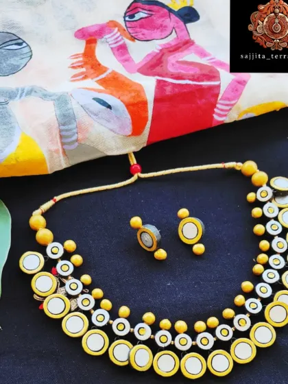 For a modern take on traditional designs, I created this two-layer necklace inspired by the classic 'gini haar'. The mirrored terracotta coins are lightweight and catch the light beautifully, offering a chic and contemporary look. It is paired with simple, matching coin-style earrings.