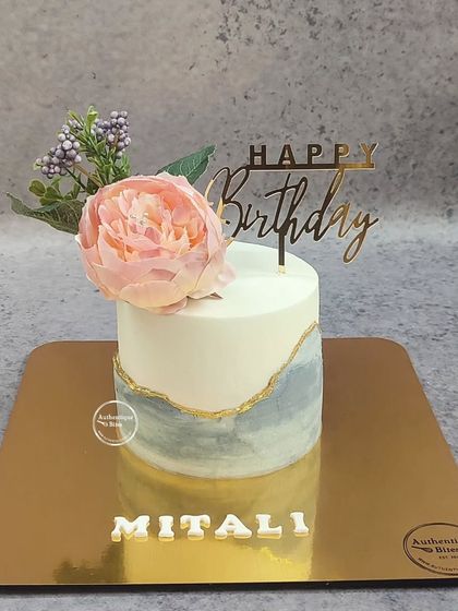A rustic fault line cake with a single, elegant peony on top. The grey marble effect with a gold-lined fault creates a simple yet sophisticated look.